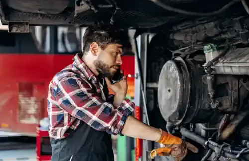 Автомеханик за ремонтом грузового автомобиля
